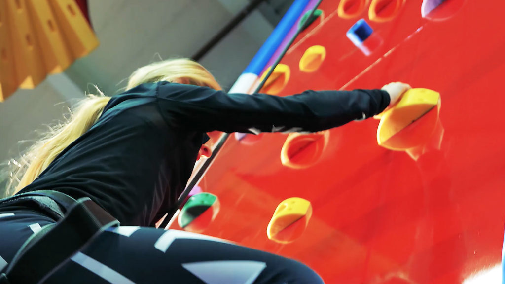 Barn klättrar på Clip 'N Climb-klättervägg hos JumpYard